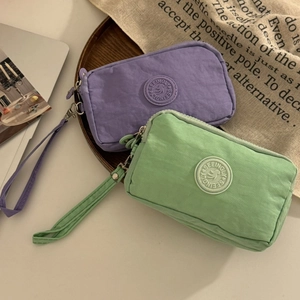 Vue détaillée des portefeuilles en tissu lavande et menthe à trois fermetures éclair
