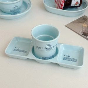 Détail du service de petit-déjeuner en céramique bleu clair avec motifs de lettres et plateau