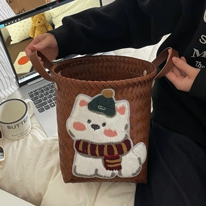 Brown woven storage basket featuring a cute cartoon animal patch and leather handles