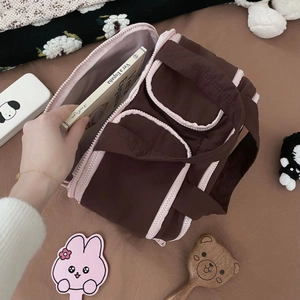 Flat lay of a large puffy cosmetic bag with dual wide openings and contrast pink piping