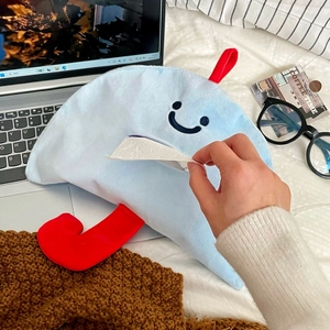 Gros plan d'un étui à mouchoirs en peluche nuage bleu avec un visage souriant mignon