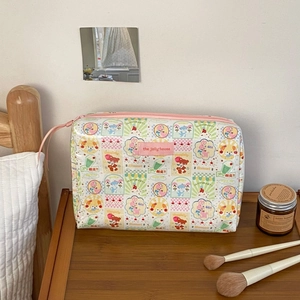 Trousse de maquillage florale sur une table de chevet en bois avec décor tamisé