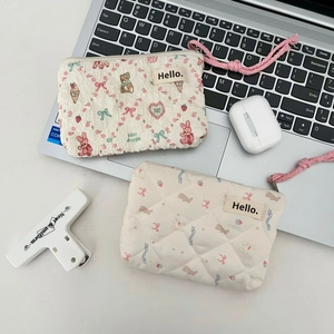 Close-up of quilted mini coin pouches with cute animal prints and woven zipper pulls