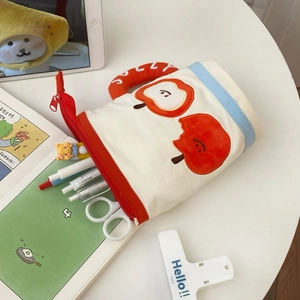 Canvas pencil case in red and white with apple embroidery and stationery on desk