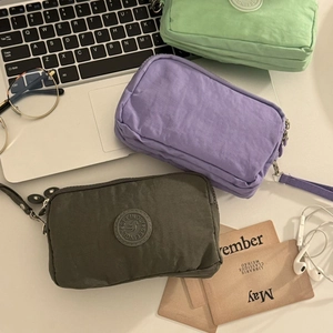 Pochettes en tissu à trois zips en violet, gris et vert avec accessoires de bureau
