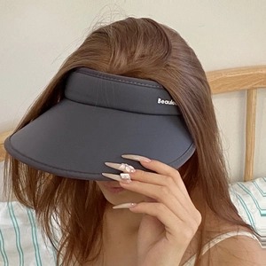 Detailed close-up of dark grey sun visor with wide brim and white logo on stretch fabric