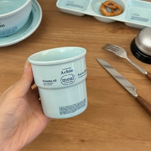 Gros plan d'un mug en céramique bleu clair avec typographie pour service de table