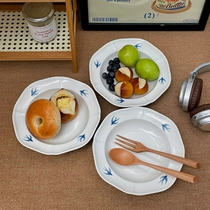 Detailed close-up of hand-painted blue swallow ceramic plates in a retro French style