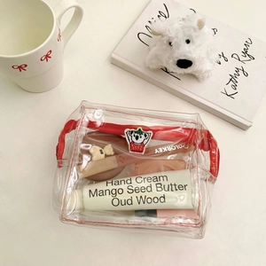 Transparent PVC makeup bag with cute koala embroidery and red zipper on a white desk
