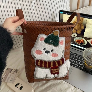 Close-up of brown rattan laundry basket featuring a cute teddy dog embroidery with winter scarf