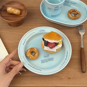 Service de vaisselle en céramique bleue avec lettrage sur fond de table en bois