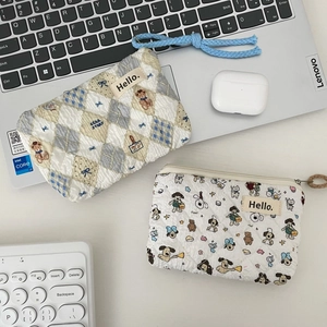 Close-up of quilted cotton mini pouches with bear and puppy patterns on a desk