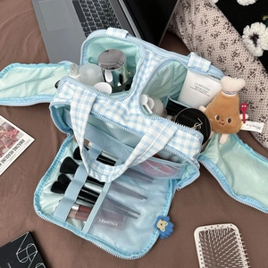 Macro detail of spacious blue plaid makeup bag with brush slots and mesh pockets
