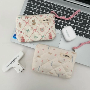Macro detail of quilted bear pattern mini pouches with woven wristlet and zipper