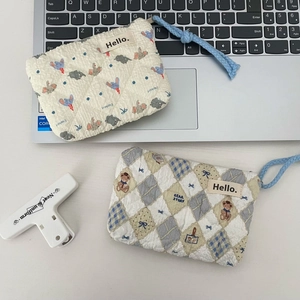 Macro detail of quilted cotton pouch featuring elephant and teddy bear floral patterns