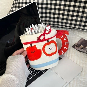 Close-up of a white mug-shaped pencil case with apple embroidery and JOLLY handle