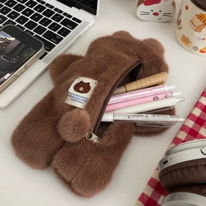 Cute brown plush bear pencil case showing stationery storage on a desktop setup