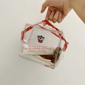 Detailed view of clear PVC makeup bag with red zipper and cute koala patch embroidery