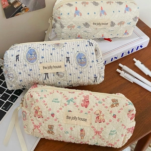Quilted cotton pencil cases with cute bear and rabbit patterns on a wooden desk