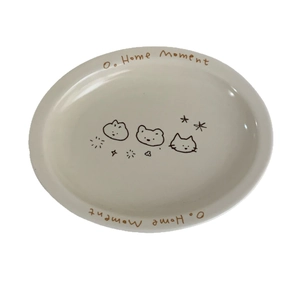 Cremefarbener Keramikteller oval mit süßen Tiermotiven und o. Home Moment Schriftzug