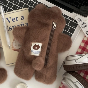 Brown plush bear pencil case for students on desk with stationery and accessories