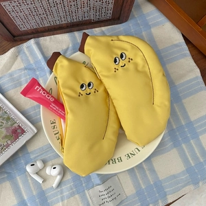Gros plan sur le porte-monnaie mignon en toile en forme de banane avec visage brodé et zip