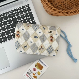 Detailed view of quilted makeup pouch with cute bear pattern and blue drawstring cord