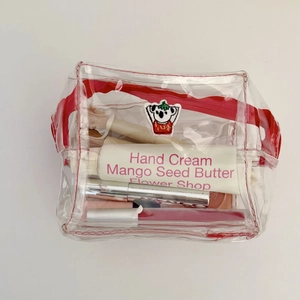 Close-up of a clear PVC cosmetic bag with a cute koala patch and a red zipper closure