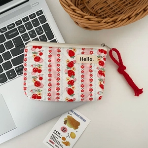 Detail shot of quilted floral pouch with red checkered pattern and Hello patch