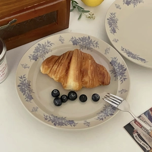 Close-up of vintage blue camellia ceramic plate featuring croissants and a silver fork