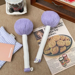 Detail of herbal moxa massage hammers with purple knitted heads and white woven handles