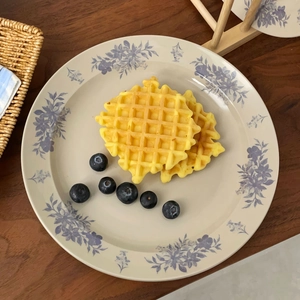 Retro ceramic dinner plate with blue flower patterns featuring waffles on wooden table