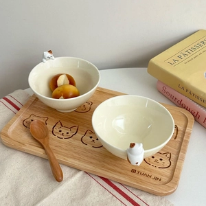 Détail de bols à chat en céramique sur plateau en bois avec cuillère assortie pour dessert