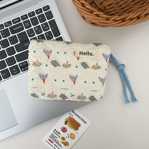 Detail of quilted elephant pouch with blue drawstring near laptop on desk
