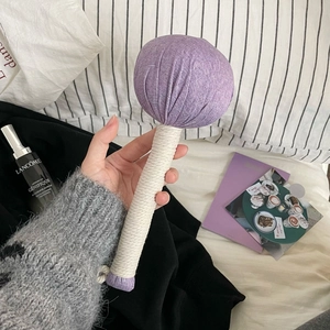 Macro detail of herbal massage hammer with purple linen head and cotton rope handle grip
