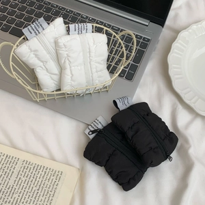 Minimalist cloud-style quilted mini coin pouch in black and white with zipper closure
