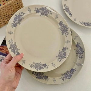 Detail of vintage blue camellia ceramic plate with elegant floral rim in a hand-held scene