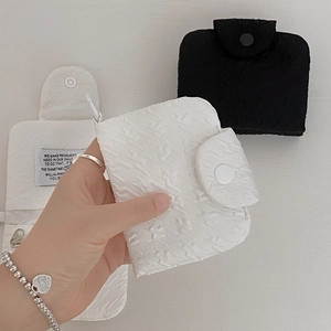 Close-up of quilted fabric mini wallet with wave texture and secure snap button closure