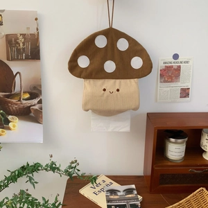 Detail of mushroom-shaped corduroy tissue holder with embroidery on vintage wall