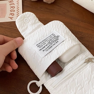 Detail of white quilted waffle fabric mini storage pouch with a brand textile label