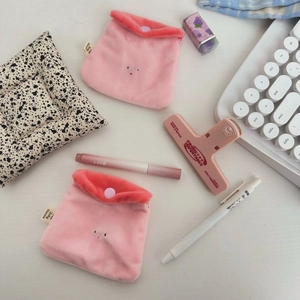 Close-up of two pink plush strawberry pudding coin purses with button closures and tags