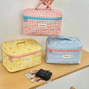 Quilted checkered makeup bags with bow embroidery in pink, yellow, and blue colors