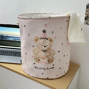 Detailed view of pink fabric laundry basket featuring cute bear print and rope handles
