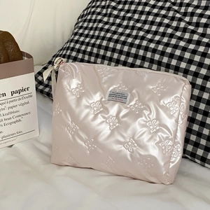 Detail der rosa Make-up-Tasche mit Schmetterlingsprägung, Schleife und Reißverschluss