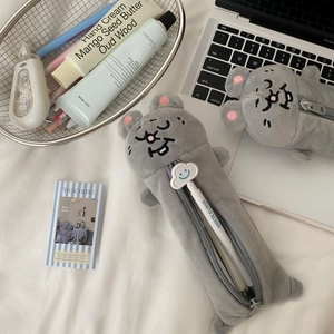 Detailed close-up of cute grey plush mouse pencil cases with cloud zipper on a white desk