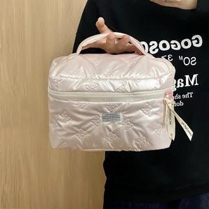 Detailaufnahme der rosa gesteppten Satin-Kosmetiktasche mit Schleifenstickerei