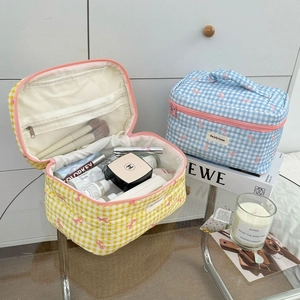 Detail of quilted cosmetic bags with interior mesh pocket and pink bow patterns