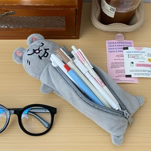 Macro shot of grey plush seal pencil case showing spacious interior with pens