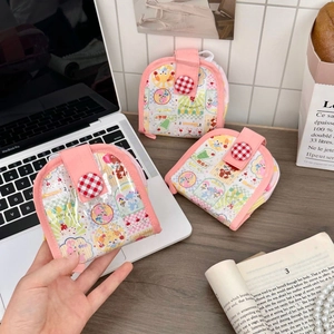 Trois mini porte-monnaie avec motifs d'ours et boutons à carreaux rouges sur un bureau