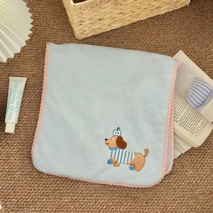 Detail of light blue coral fleece towel with cartoon dog embroidery and pink wavy lace edges